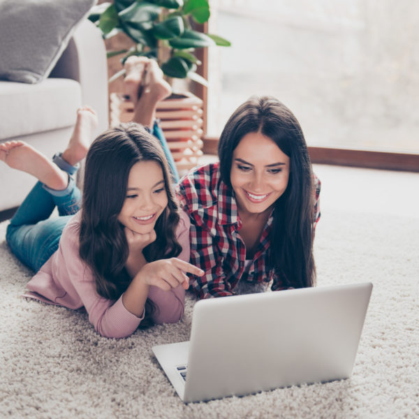 Meisje ligt naast vrouw op de grond in huiskamer en kijken op laptop | De VO Gids 2027