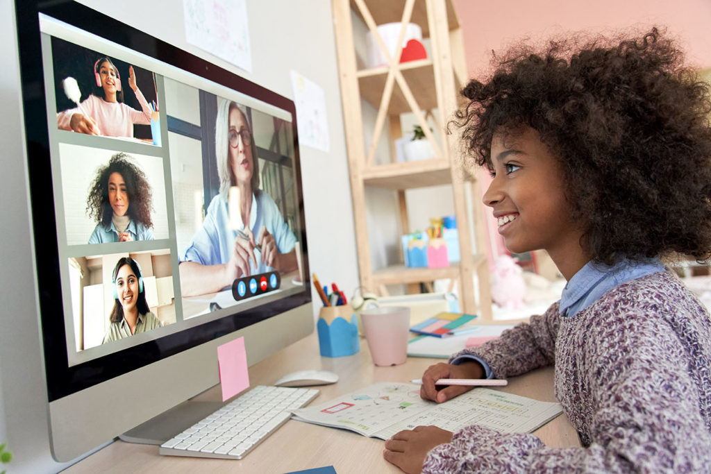 Meisje kijkt blij naar scherm tijdens Virtuele Open Dag | De VO Gids 2026