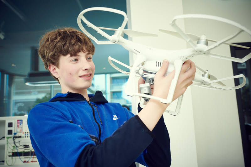 Jongen houdt witte drone omhoog De VO Gids 2026