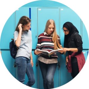 3 leerlingern staan voor turkooizen kastjes in gang in boek te kijken VO Gids 2026