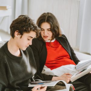 Ouder kijkt met kind naar boek in zijn handen | De VO Gids 2026