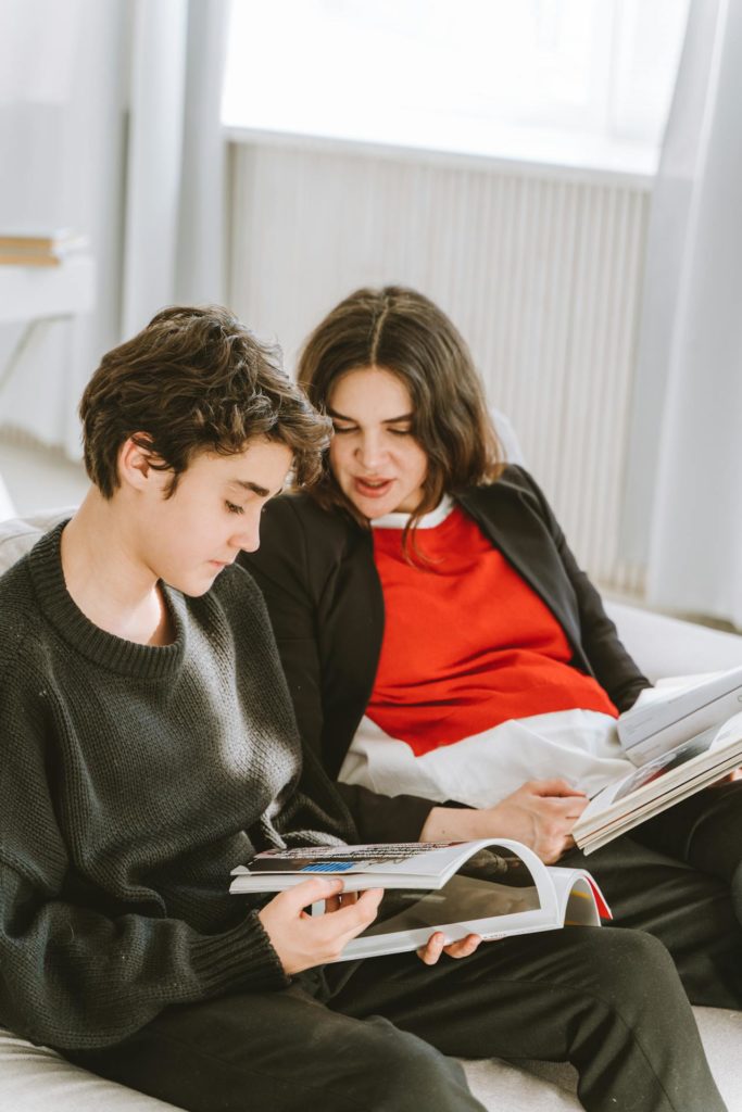 Ouder kijkt met kind naar boek in zijn handen | De VO Gids 2026