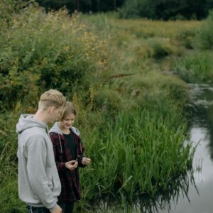 Leraar en leerling staan bij water in groen gebied | De VO Gids 2026