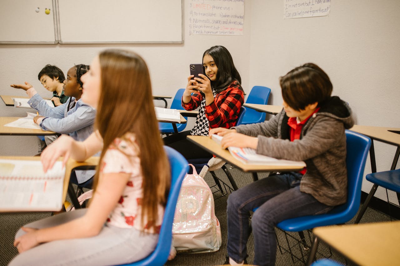 Meisje neemt foto op smartphone in de klas | De VO Gids 2026