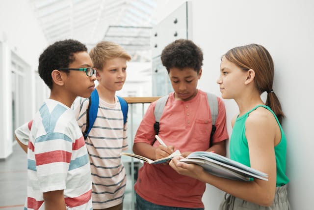 4 kinderen staan bij elkaar in gang van schoolgebouw | De VO Gids 2026