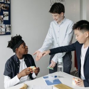 Jongen speelt met Rubik's Cube en 2 andere jongens steken hun hand uit | De VO Gids 2026