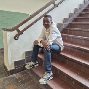 Abraham zit op trap in schoolgebouw en kijkt in camera | De VO Gids 2027